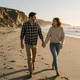 Happy couple walking on a California beach at sunset - trucker dating success